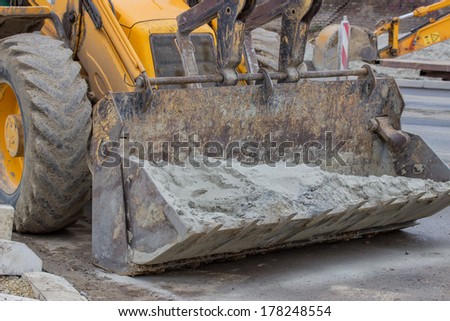 bulldozer with full of sand in a front loader on road construction site