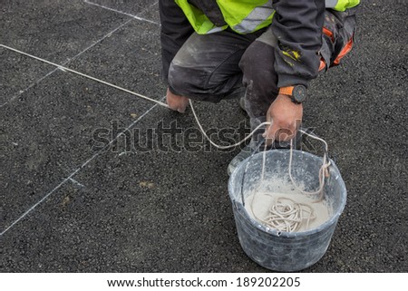 road paint worker with chalk line, string covered in chalk dust