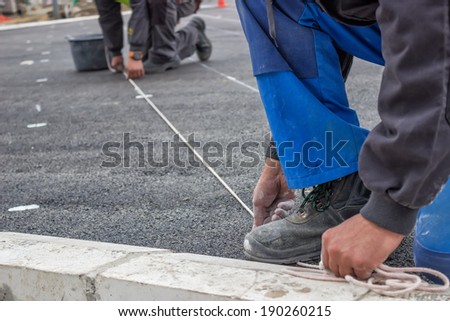 Road workers chalking for marking new road lines. Just pull the line high and straight up.