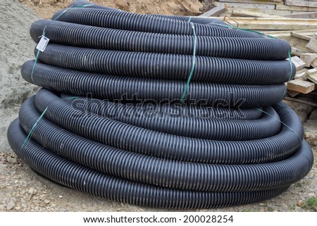 Roll of black flexible conduit nylon pipe at construction site