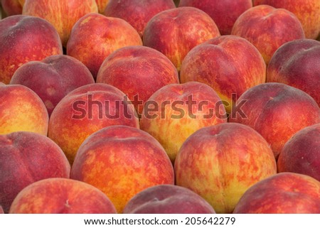 Farmers market peaches background. At the farmers market local growers come and sell their freshly picked crops at reasonable prices. Selective focus.