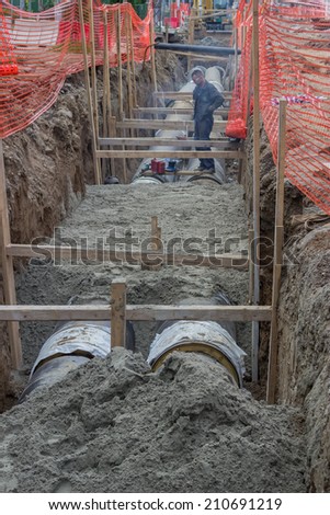 BELGRADE, SERBIA - AUGUST 07 :  Welder working in trench on a pipeline at construction site. Insulated pipes to connect a new buildings on heat system. At street Vojvode Stepe in August 2014.