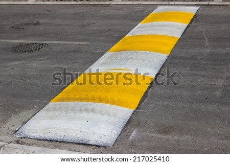 Freshly painted speed bump for slowing traffic near school. Selective focus.