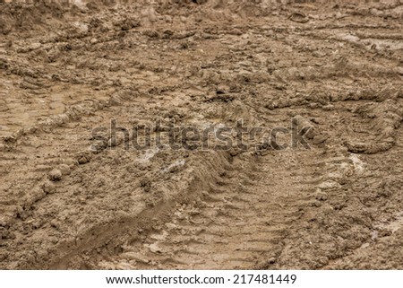 Tire tracks in the mud, dirty road background. Selective focus