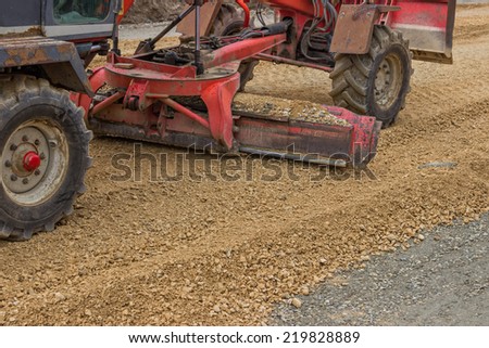 Close up of motor grader working on gravel leveling for road construction.  Selective focus.
