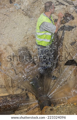 BELGRADE, SERBIA - OCTOBER 01: Worker cut section of water main pipe for installation new valve. Teeing into a water main. Selective focus. At street Vojvode Stepe in October 2014.