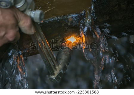 Oxy Acetylene torch. Cutting torch is used to cut a steel pipe with water. Selective focus.