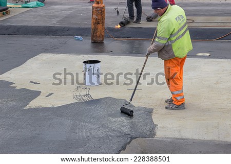 BELGRADE, SERBIA - OCTOBER 29: Builder workers at floor slab insulation work, insulation material over concrete slabs to keep water out. At construction site in October 2014.
