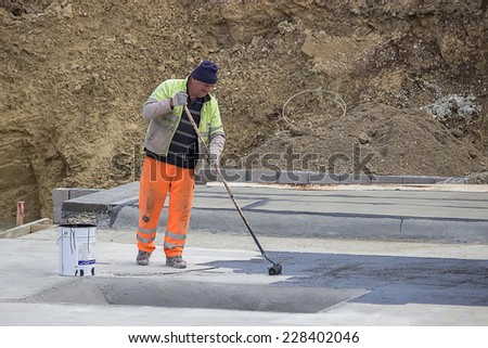 BELGRADE, SERBIA - OCTOBER 29: Builder workers at floor slab insulation work, insulation material over concrete slabs to keep water out. At construction site in October 2014.