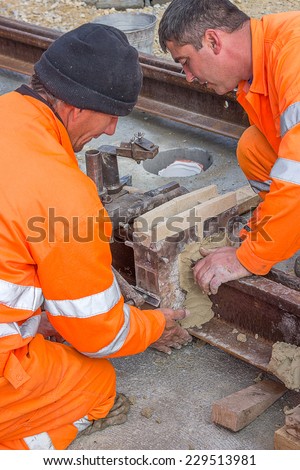 BELGRADE, SERBIA - OCTOBER 28: Worker installing mould and using mould material on tram rail before thermit welding process. At construction site in October 2014.