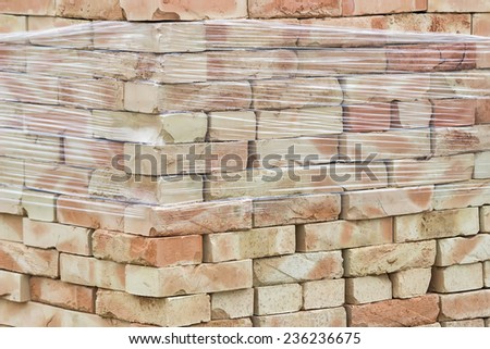 pallet of yellow clay bricks stacked without mortar background