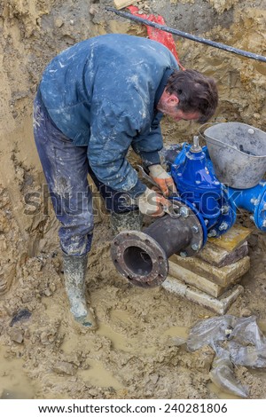 BELGRADE, SERBIA - DECEMBER 26: Installing water line, water main tap.  Connect a T junction for new commercial building water supplies. Selective focus. At construction site in December 2014.