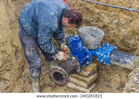 BELGRADE, SERBIA - DECEMBER 26: Installing water line, water main tap.  Connect a T junction for new commercial building water supplies. Selective focus. At construction site in December 2014.