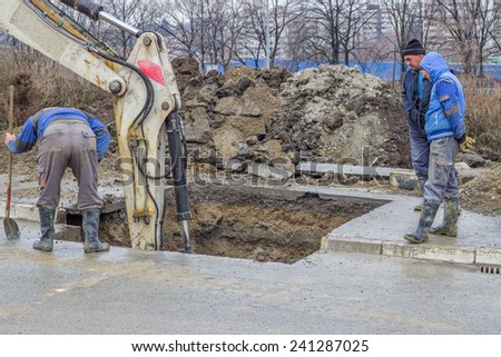 BELGRADE, SERBIA - DECEMBER 27: Excavator digging the ground, hunting for water leaks. Found the leaking in water pipes in December 2014.