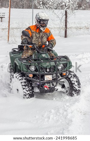 BELGRADE, SERBIA - JANUARY 06: Extreme winter sports, boy driving atv vehicle at winter. Snow Sport on 4 wheeled motor ATV.  All terrain vehicle in motion at winter on January 2015.