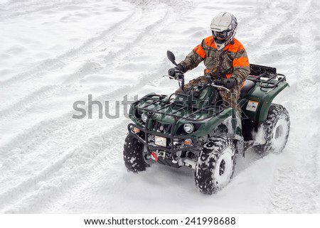 BELGRADE, SERBIA - JANUARY 06: Extreme winter sports, boy driving atv vehicle at winter. Snow Sport on 4 wheeled motor ATV.  All terrain vehicle in motion at winter on January 2015.