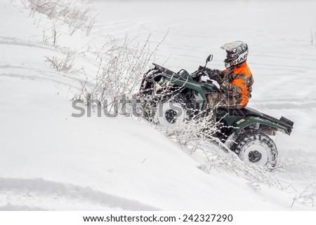 BELGRADE, SERBIA - JANUARY 06: Extreme winter sports, boy driving quad vehicle at winter. Snow Sport on 4 wheeled motor ATV.  Motion blur. All terrain vehicle in motion at winter on January 2015.