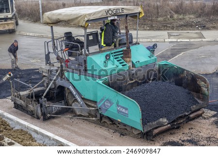 BELGRADE, SERBIA - JANUARY 21: Asphalt paving machine full of fresh asphalt. At  road construction site in January 2015.