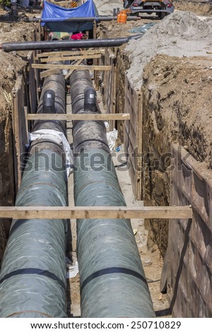BELGRADE, SERBIA - AUGUST 23: Installing the district heating pipe systems. Laying huge pipe in a trench. At construction site in August 2014.