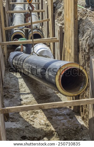 BELGRADE, SERBIA - AUGUST 28: Installing the heating pipe systems. Laying huge pipe in a trench. At construction site in August 2014.