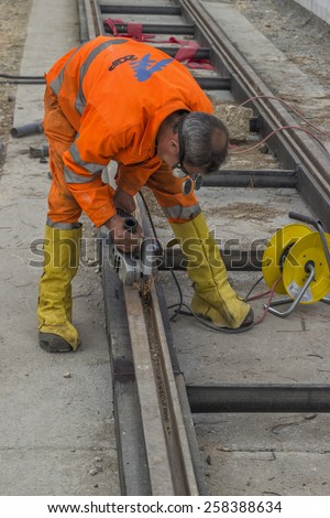 BELGRADE, SERBIA - NOVEMBER 11: Rail worker using angle grinder to grinding tramway track, worker grinding. At street Vojvode Stepe in November 2014.
