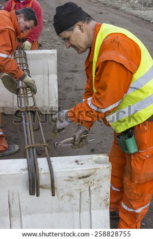 BELGRADE, SERBIA - JANUARY 14: Workers tying rebar using steel wire and pliers. At street Vojvode Stepe in January 2015.
