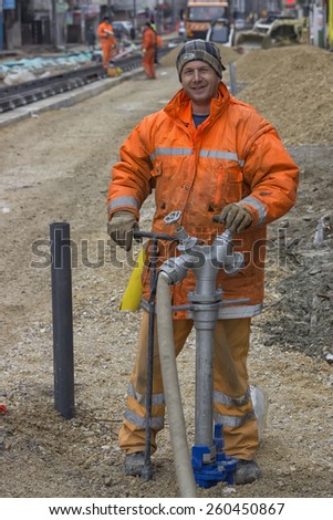 BELGRADE, SERBIA - MARCH 08: Worker with wrench starts to turn off water valve on fire hydrant to stop the water flow. At street Vojvode Stepe in March 2015.