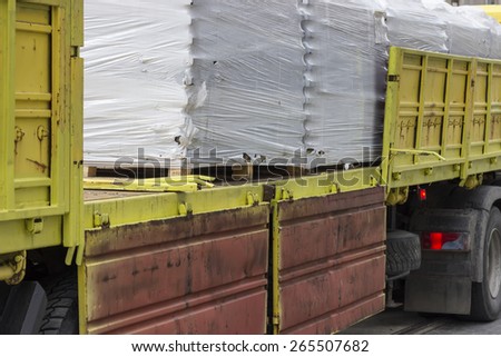 Truck full of concrete brick on wooden pallets. Abstract: loading and delivery.