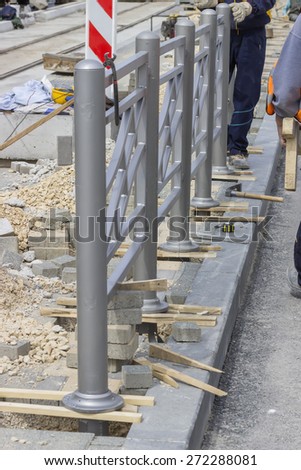 Workers install street protective fence, fence installation. Selective focus and shallow dof.
