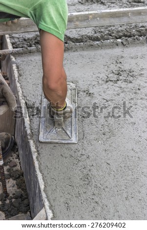 Concrete leveling with trowel, spreading poured concrete. Selective focus.
