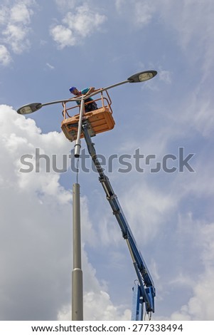 BELGRADE, SERBIA - MAY 10: Worker during installation of metal pole with street lamp, street light. Selective focus. Working on a street reconstruction project in May 2015.