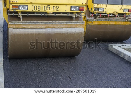 Close of two road roller compacting asphalt. Compactor roller during street paving works.