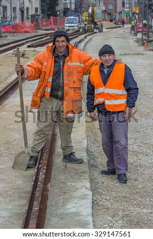 BELGRADE, SERBIA - MARCH 08, 2015: Rail workers posing with shovel. Tram rails under construction at street Vojvode Stepe. Shallow dof.