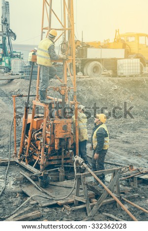 BELGRADE, SERBIA - OCTOBER 26, 2015: Core dirll workers and geotehnical core drilling rig. Made with shallow dof, vintage style.