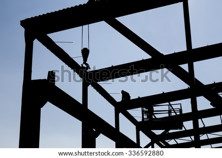Silhouette of the workers dissembling industrial constructions.