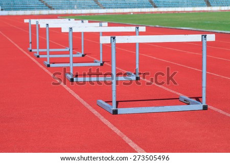 Stadium track and field athlete hurdling