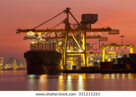 Cargo ship to light in the morning before sunrise.