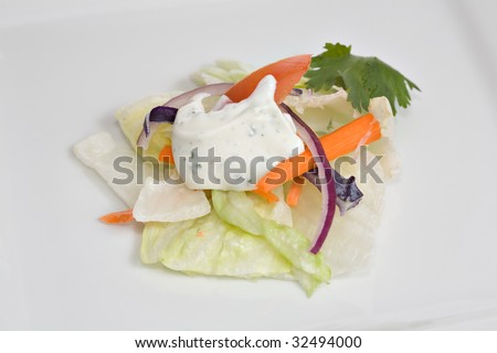 Fresh garden salad served with ranch dressing on top.