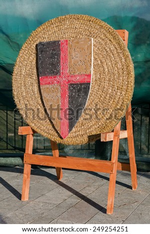 Medieval archery target with old banner with holes made by arrows