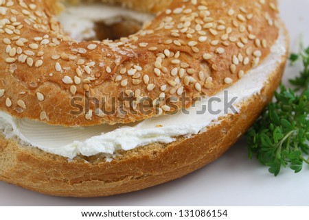 Bagel with cream cheese with watercress garnish, close up