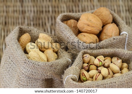 Walnuts, pistachio nuts and peanuts in jute bags