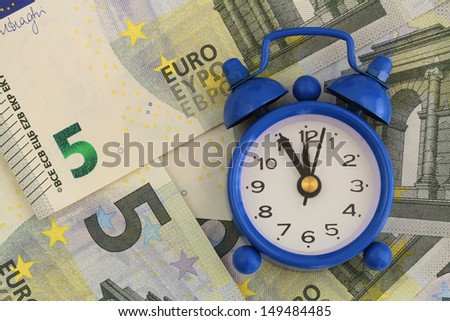 Time is money concept, miniature clock on banknotes
