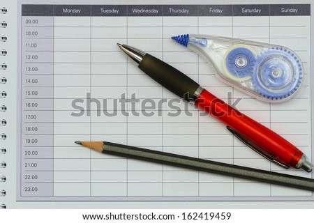 Pencil, pen and pen corrector on open agenda