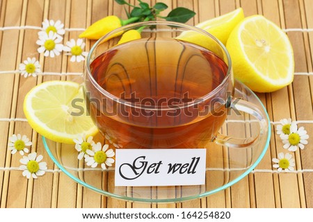 Get well card with cup of chamomile tea and lemon on bamboo mat