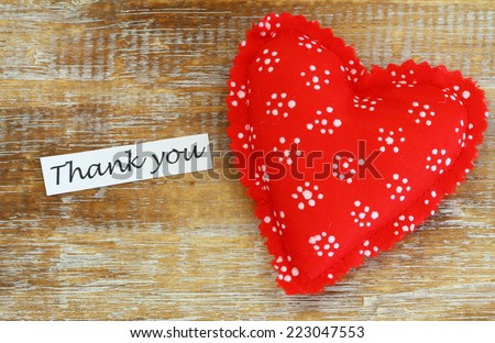 Thank you card with red heart on wooden surface