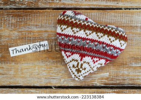 Thank you card with knitted heart on wooden surface