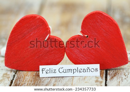Feliz Cumpleanos (which means Happy Birthday in Spanish) with two red wooden hearts