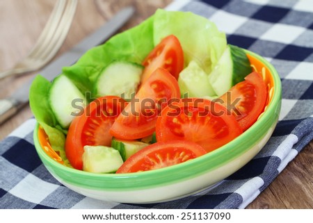 Tomato and cucumber salad in bowl, closeup