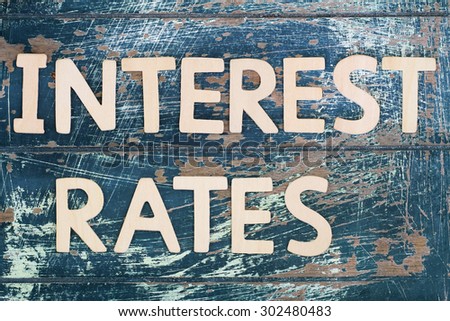Interest rates written with wooden letters on rustic wooden surface