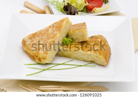 Spanish Cuisine. Spanish Omelet served in slices. Tortilla de patatas. White background. Focus on foreground.
